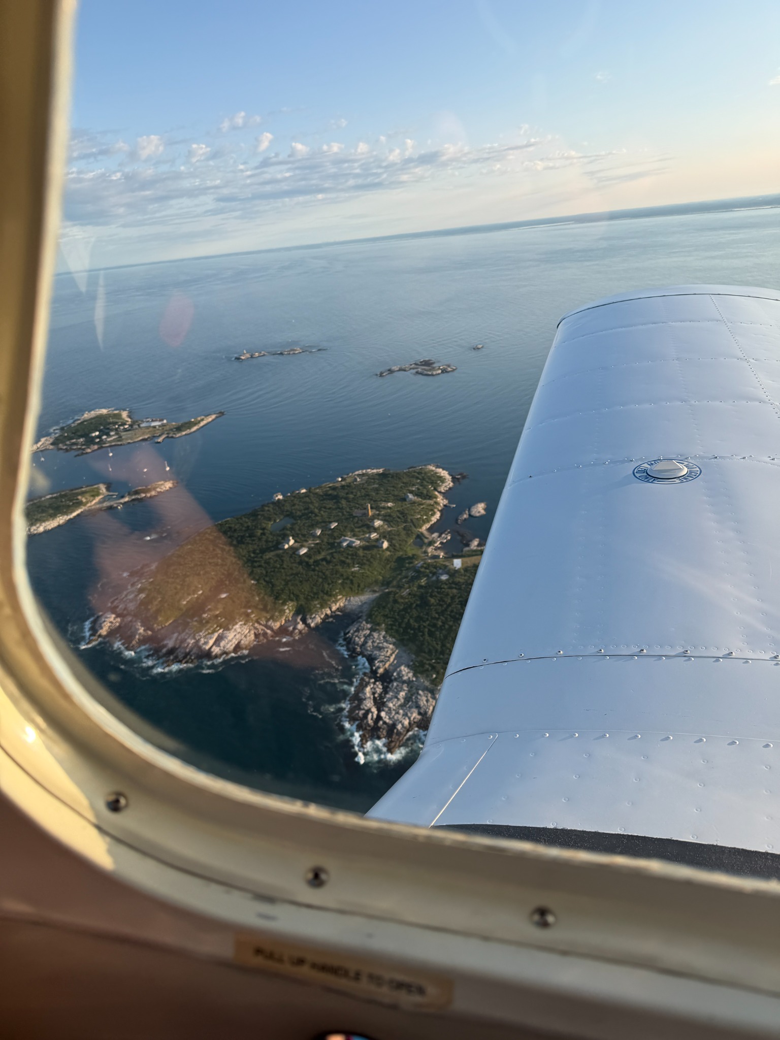 Rocky New England islands seen past the wing of Marvelous Moe
